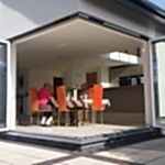 family sits by cornerless bifold doors